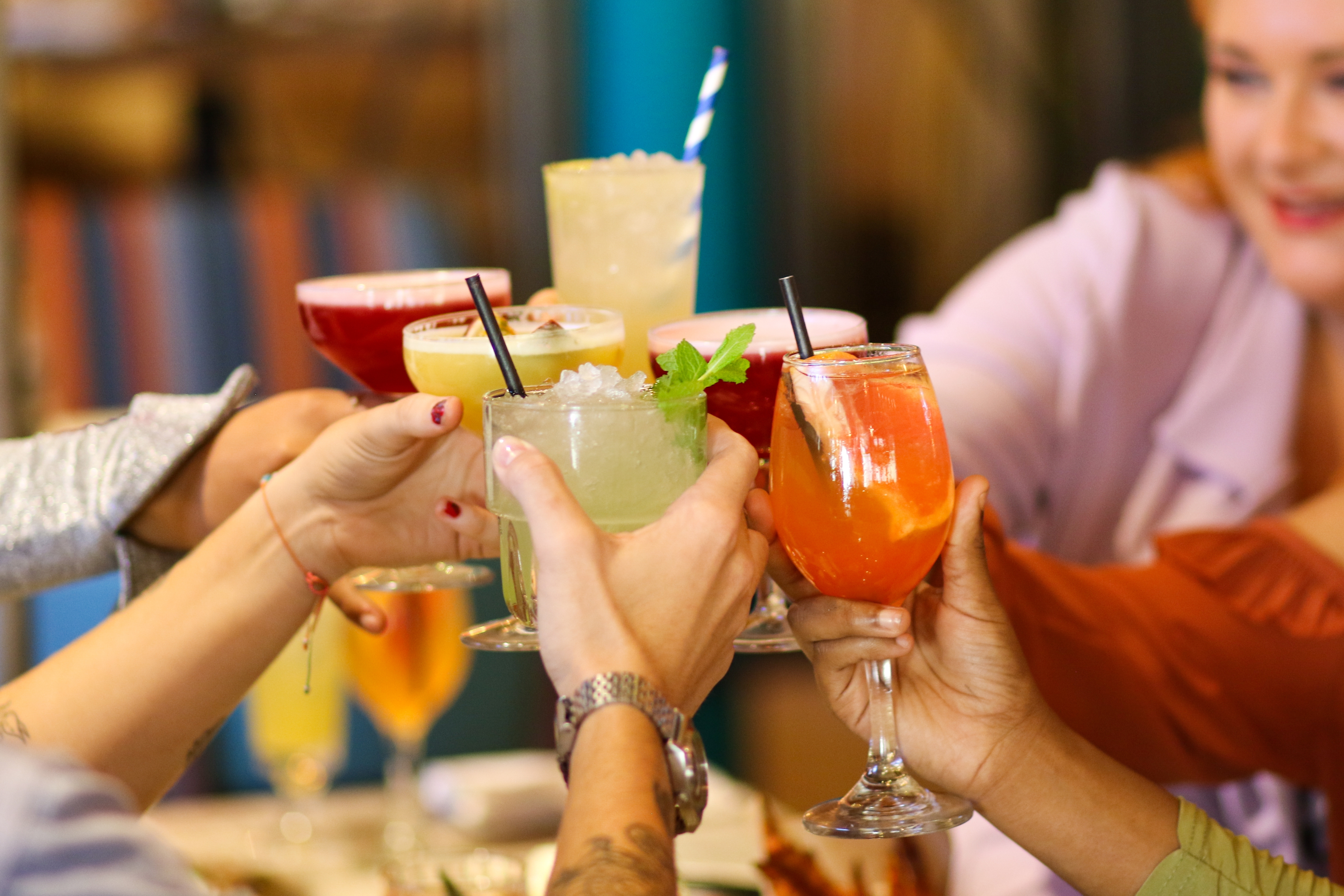 Group cheers with tropical cocktails at Happy Hour at Turtle Bay