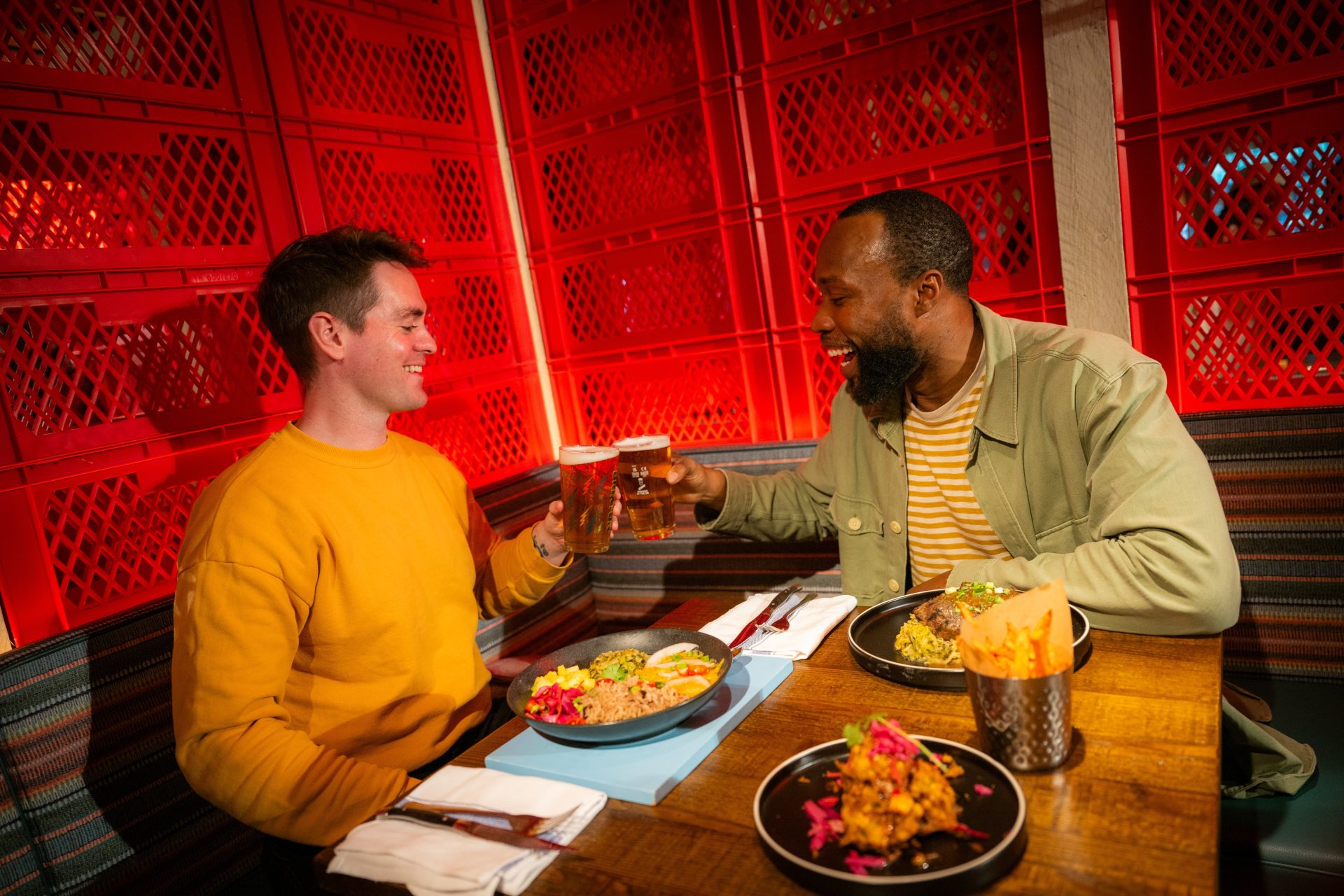 2 Friends cheers with food and pints of beer 2