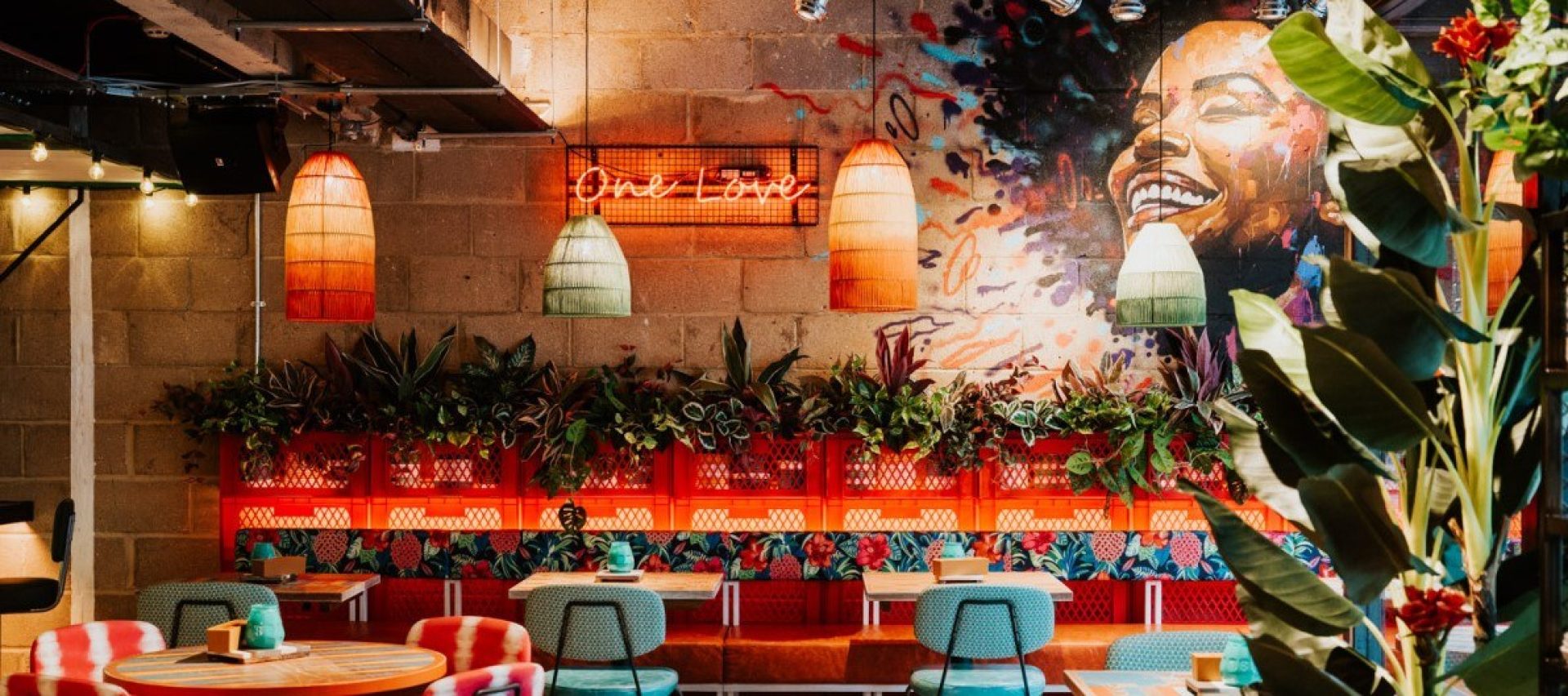 Turtle Bay interior with One Love neon sign and happy woman